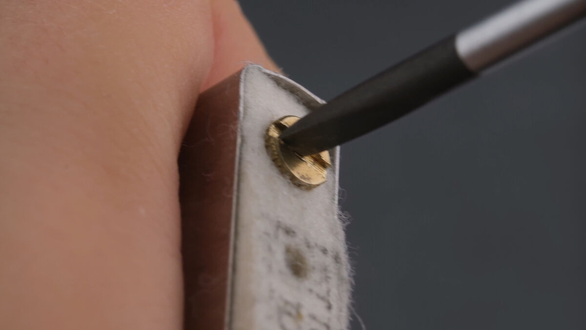 Lösen der Feuersteinschraube am Zippo-Benzinfeuerzeug